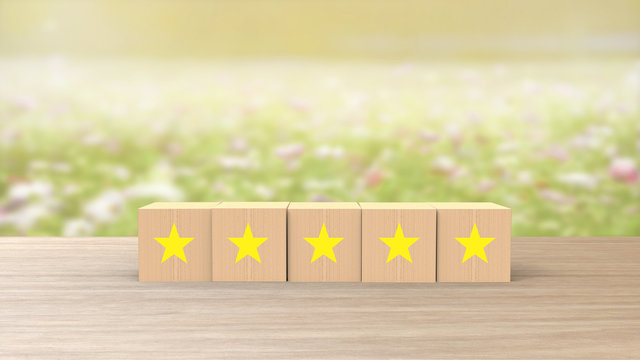 Wooden Cube Five Yellow Star Review On Blur Field Of Flowers Background. Service Rating, Satisfaction Concept. Reviews And Comments Google Maps, Tripadvisor, Facebook. Online Evaluations.