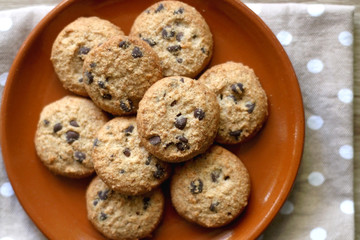 Chocolate chip cookies and polka dot napkin on wooden table. Top view.