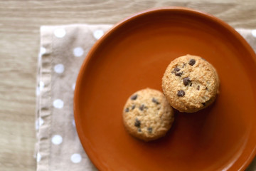 Chocolate chip cookies and polka dot napkin on wooden table. Top view.