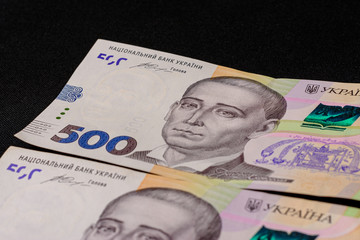 A lot of Ukrainian hryvnias, face value 500 hryvnias on a black background, nicely laid out money on black.