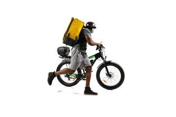 Fototapeta na wymiar Too much orders. Contacless delivery service during quarantine. Man delivers food during isolation, wearing helmet and face mask. Taking food on bike isolated on white background. Safety. Hurrying up.