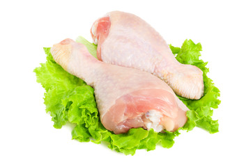 Raw chicken legs and green salad isolated on white background