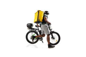 Obraz premium Too much orders. Contacless delivery service during quarantine. Man delivers food during isolation, wearing helmet and face mask. Taking food on bike isolated on white background. Safety. Hurrying up.