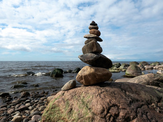 Rocky beach Baltic Sea, rocks overgrown with algae and moss, balanced piles of pebbles