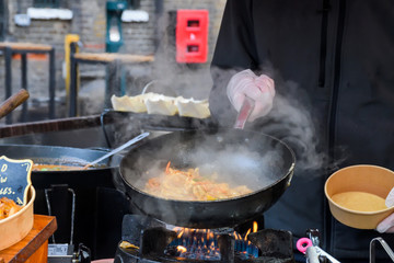 Professional chef and fire. Cooking vegetables and food