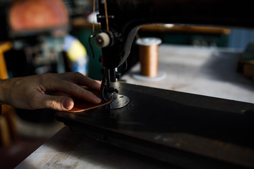 Fototapeta na wymiar A leather craftsman works in a workshop. 