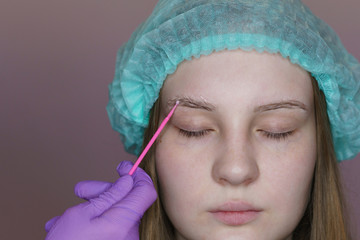 Apply eyebrows for long-term styling. Eyebrow biolamination. Cosmetic procedure in spa salon. Beautician at work.