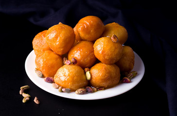 Arab sweet desserts for lokma post on a black background.