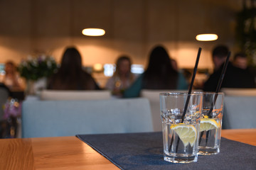 Water with lemon, drink, cocktail on the table in cafe with beautiful blurred background