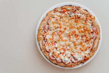 Homemade hot pizza with salami, mushrooms, pepper and cheese. Top view of delicious, traditional pizza.