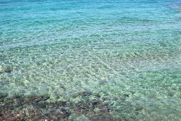 Fototapeta na wymiar Calm clean, ultramarine water surface with little waves 