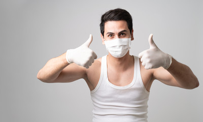 A Man wearing surgical mask and rubber glove showing thumbs up,.Concept coronavirus pandemic to prevent virus infection outbreak by wearing mask and medical glove in public. Social distancing covid19.