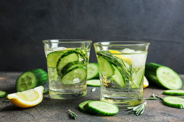Glasses of infused cucumber water on dark background