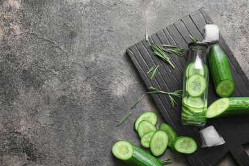 Bottle of infused cucumber water on dark background