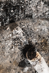 Smoked cigarette on the ashtray with ashes around. Cigarette butt and ashes.