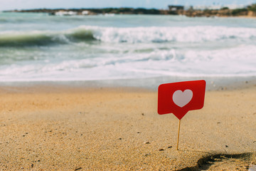 Fototapeta premium LIMASSOL, CYPRUS - MARCH 31, 2020: red heart on stick on sand near mediterranean sea