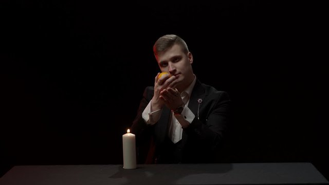 Illusionist showing trick with fire and tangerines