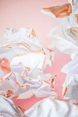 Crumpled paper on pink background.