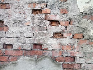 old red brick wall with remnants of cement mortar