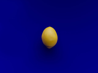 One yellow Lemon over a vibrant blue background viewed from above - 3d rendering
