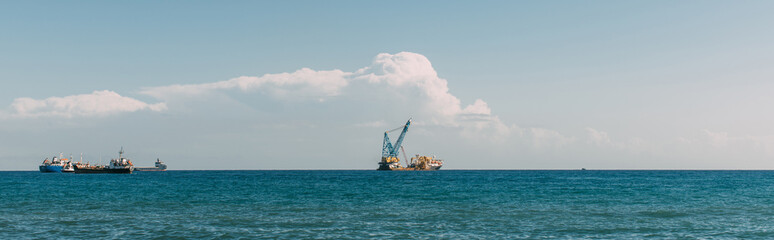 Obraz premium panoramic shot of ships in blue mediterranean sea against blue sky