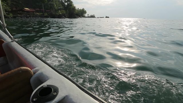 Splashing waves of a fast of a motorboat arriving to an exotic holiday location on the Pacific shore of Colombia