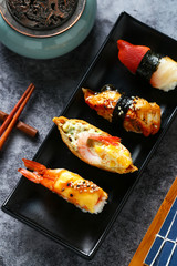Japanese sushi in black plate on dark background