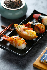 Japanese sushi in black plate on dark background