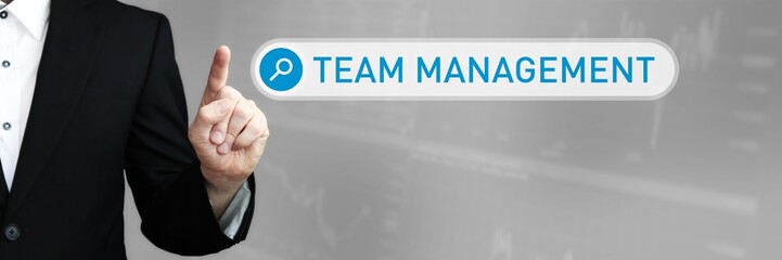 Team Management. Man in a suit points a finger at a search box. The word Team Management is in the search. Symbol for business, finance, statistics, analysis, economy