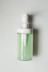 dispenser with green liquid soap on a white background from above