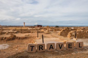 wooden cubes with travel lettering near ruins of ancient House of Theseus