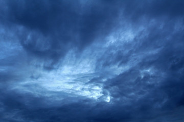 Naklejka na ściany i meble Blue clouds on a dark stormy sky. Soft focus.