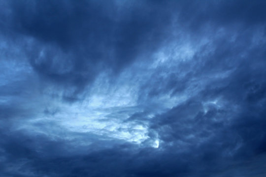Blue clouds on a dark stormy sky. Soft focus.