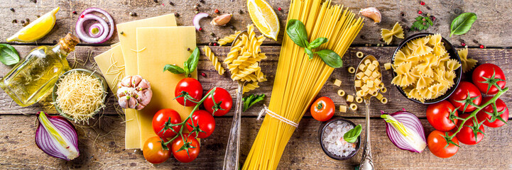 Assortment set of various raw pasta and condiments. Cooking italian pasta concept with fresh herbs...