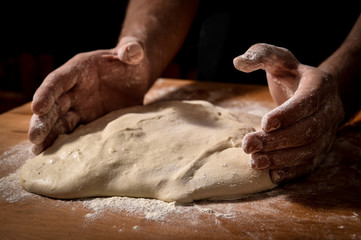 pizza dough with chef's hands dirty with flour