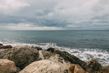 Fototapeta na wymiar mediterranean sea near rocks against sky with clouds