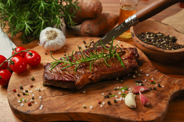 Steak medium gebraten auf Brettchen mit Rosmarien | Rumpsteak medium