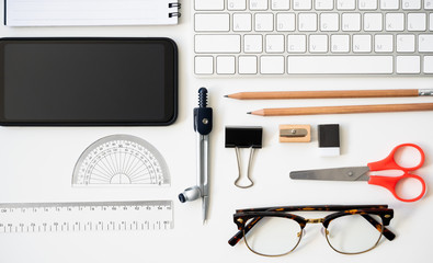 Top view table desk of office architect pencil, compasses tool, ruler, rubber, protractor grid, sharpener, glasses, smartphone, keyboard, scissors, notebook background.