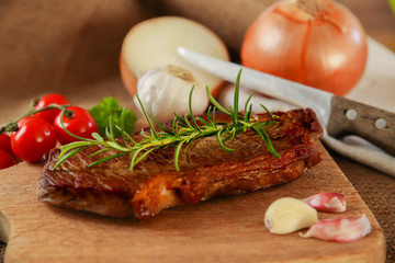 Steak medium gebraten auf Brettchen mit Zwiebeln und Rosmarien | Rumpsteak medium