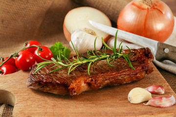Steak medium gebraten auf Brettchen mit Zwiebeln und Rosmarien | Rumpsteak medium