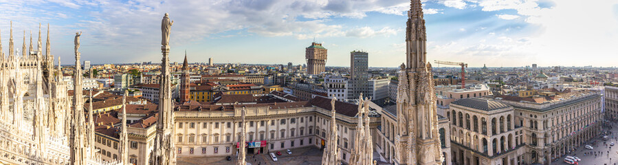 Fototapeta na wymiar Panoramic view from the decorated stone carvings of the Cathedral of Milan - Duomo di Milano roof in Milan city, Italy