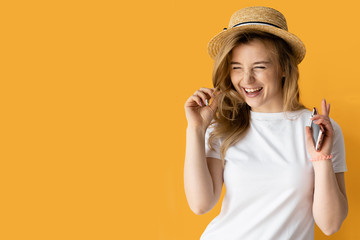 Portrait of a happy smiling woman holding a smartphone, female straw hat dressed. A cheerful smile and happiness.