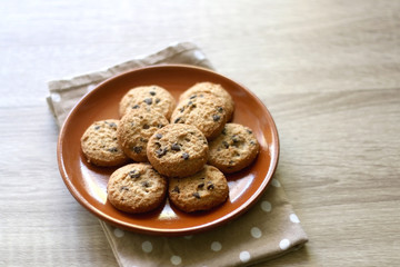 Chocolate chip cookies and polka dot napkin on wooden table. Selective focus.