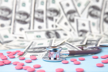 Medical stethoscope with reflection and colorful pink tablets. Blisters of pills in blue...
