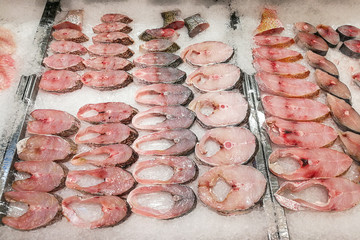 Slices of raw fresh fish block on ice for sale in supermarket