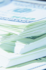 Stacks of US Dollar bills as symbol of profit, success and investment. Shot with shallow depth of field. Selective focus.