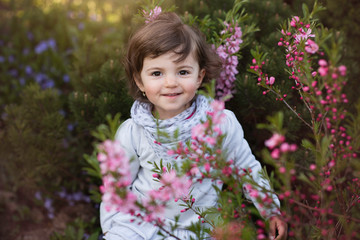 cute little girl outside on a spring sunny day with flowers