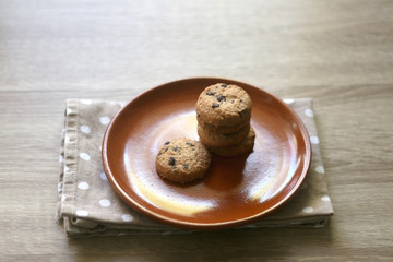 Chocolate chip cookies and polka dot napkin on wooden table. Selective focus.