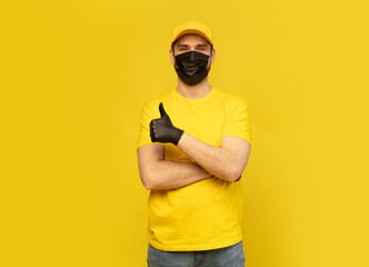 Fototapeta na wymiar Delivery man in yellow cap, t-shirt uniform, mask gloves isolated on yellow background. Coronavirus 2019-ncov concept