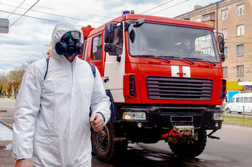 The savior of the fire service disinfects the streets of the city. Preventive methods against coronavirus. Specialist in hazmat suits cleaning disinfecting coronavirus cells epidemic, pandemic health 